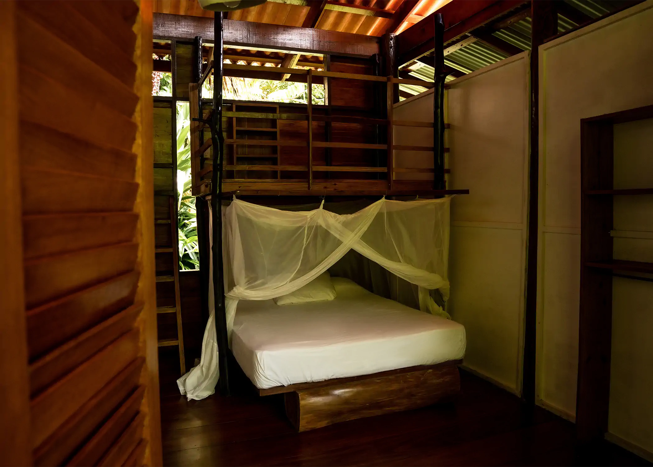 Wooden bunk beds with mosquito nets at Cacao Farm House