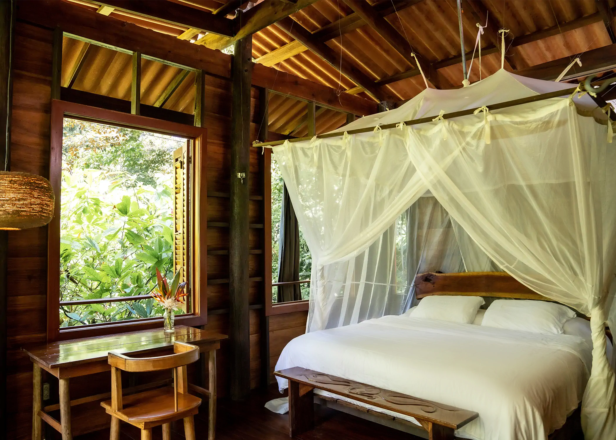 Cacao Farm House bedroom with canopy mosquito net and jungle views