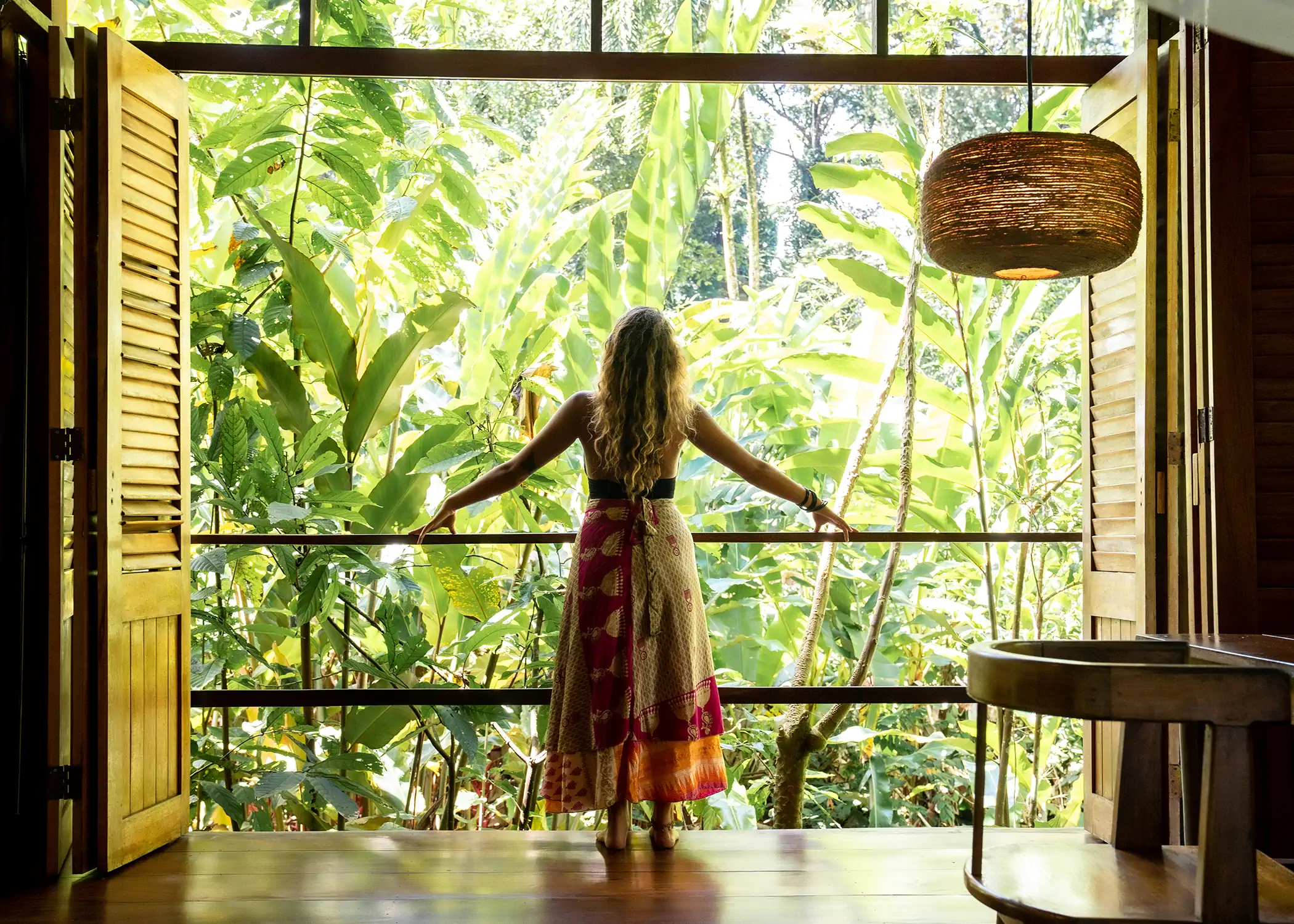 Guest enjoying panoramic jungle views from Cacao Farm House open balcony