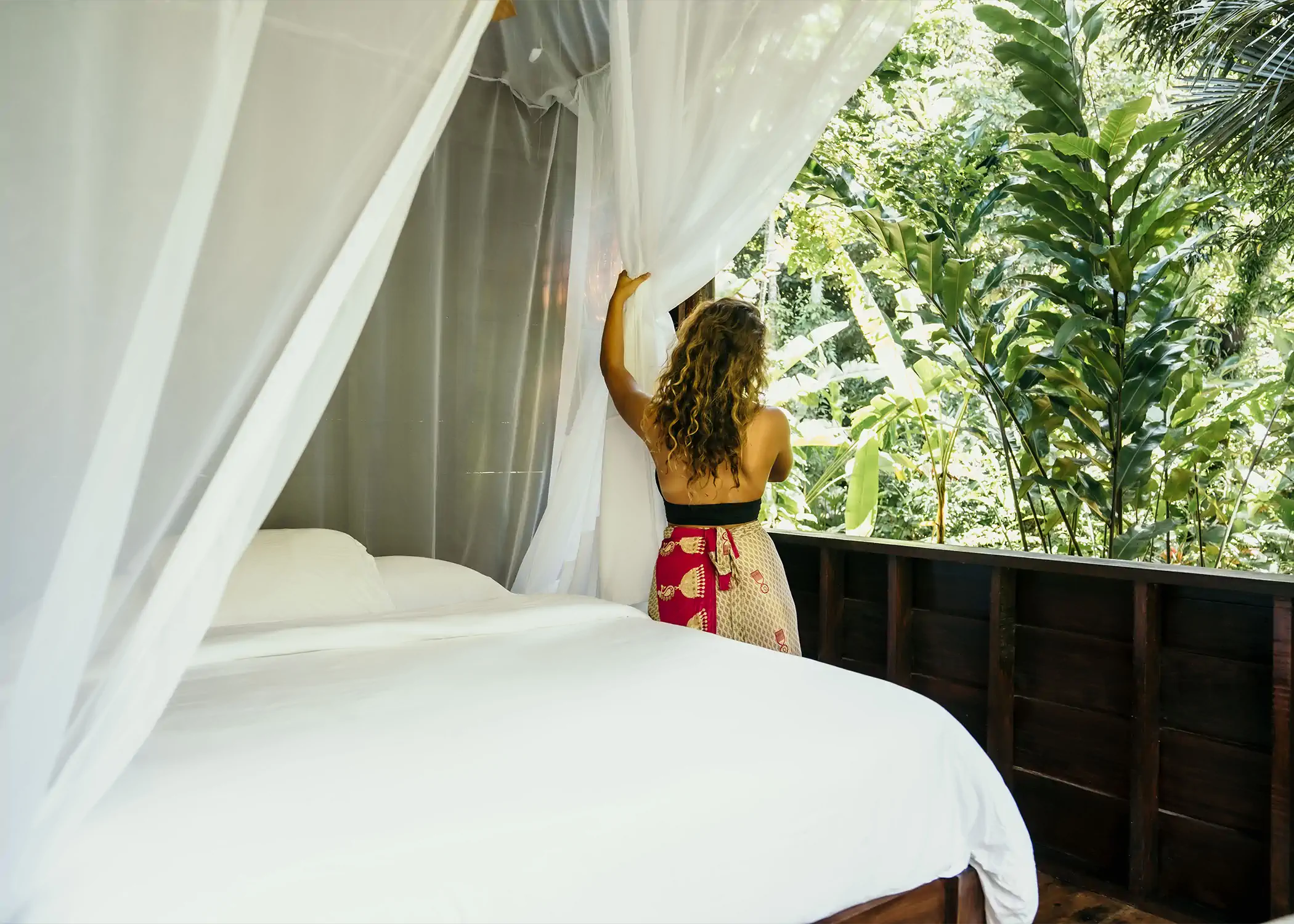 Luxury treehouse bedroom with canopy bed overlooking tropical jungle rainforest
