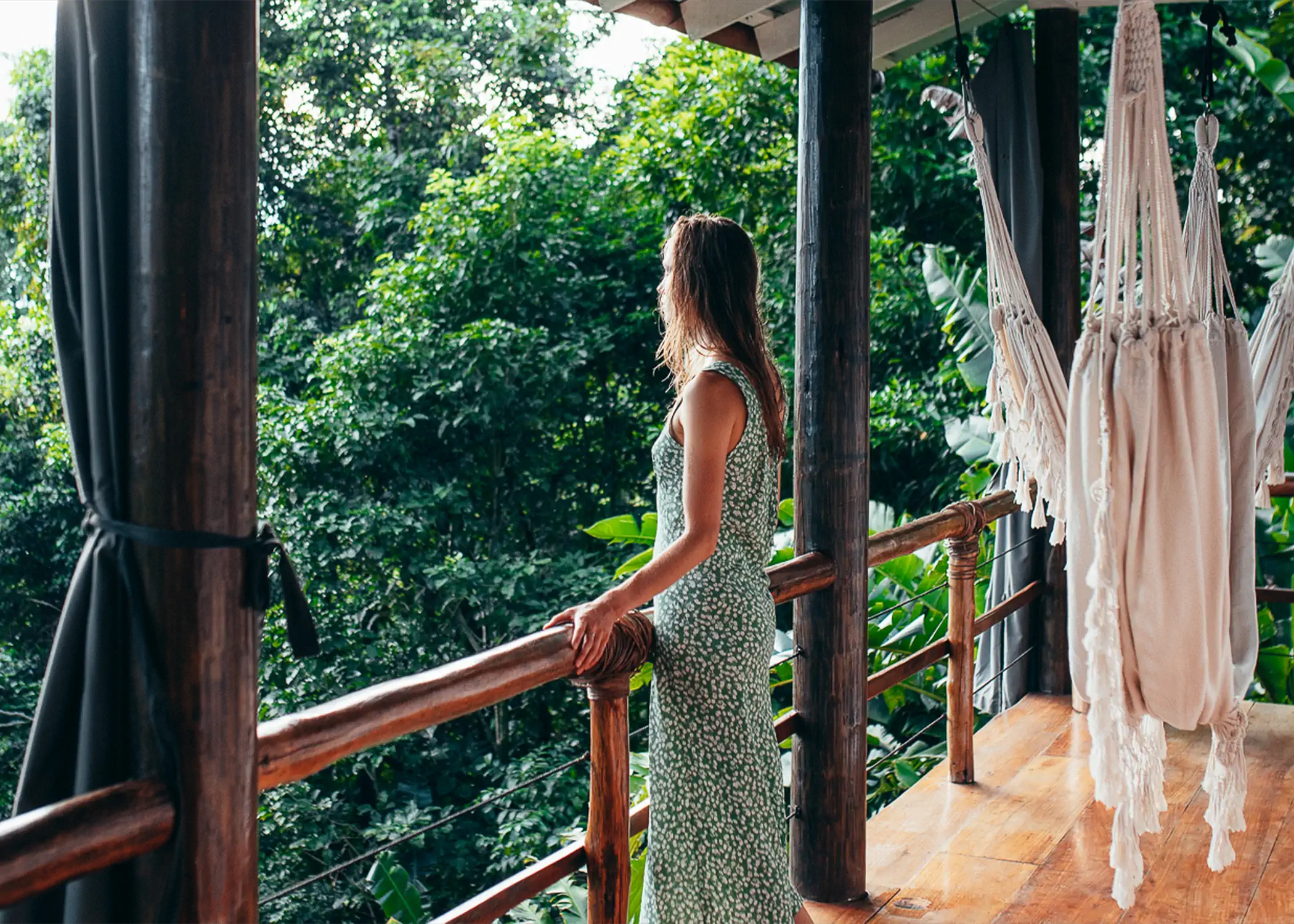 Woman enjoying Family Treetop Bungalow balcony with jungle canopy views