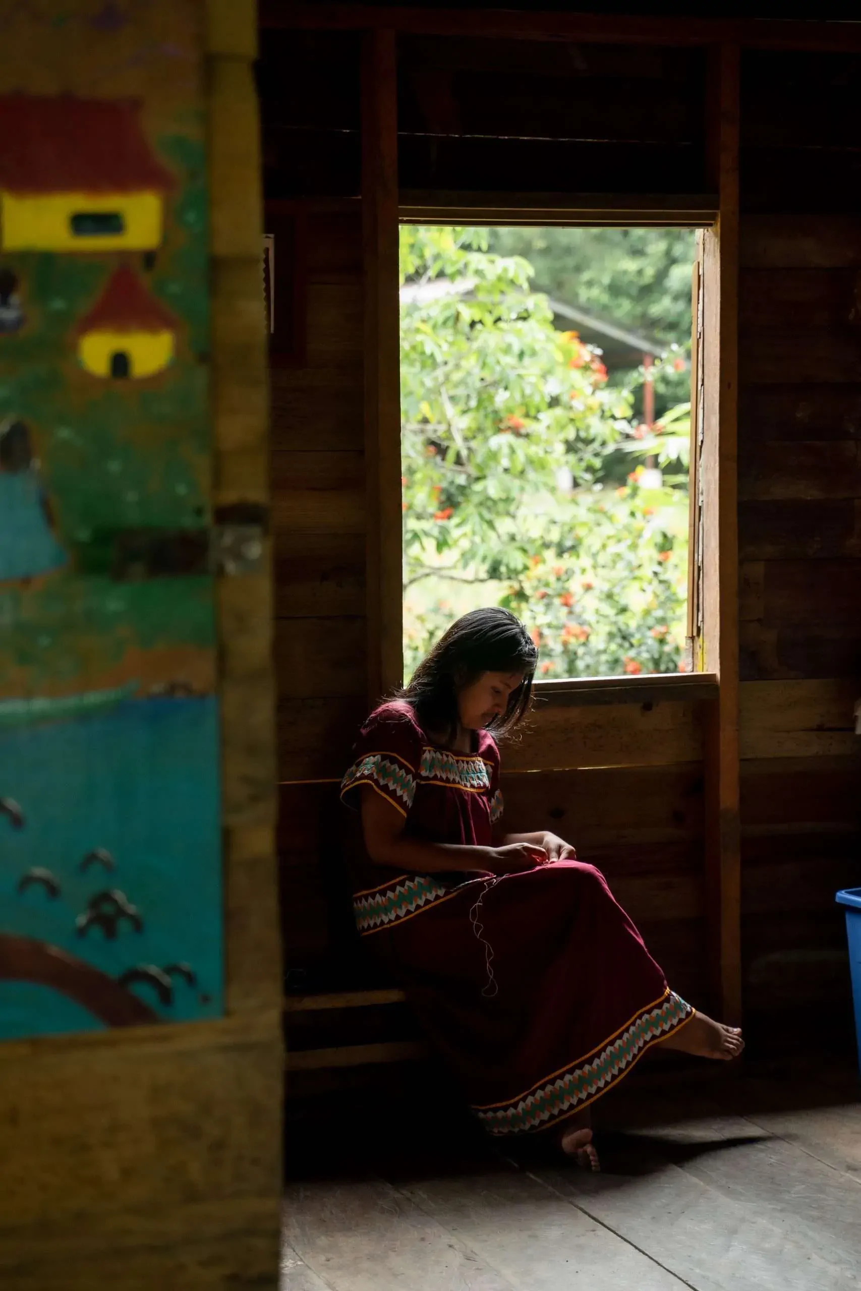 Young Ngäbe-Buglé girl reading in traditional dress at Bahia Honda school