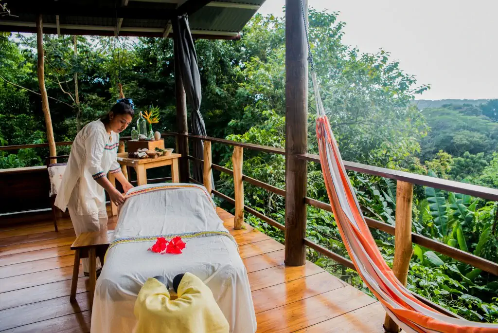 Outdoor spa massage table setup overlooking rainforest at wellness retreat